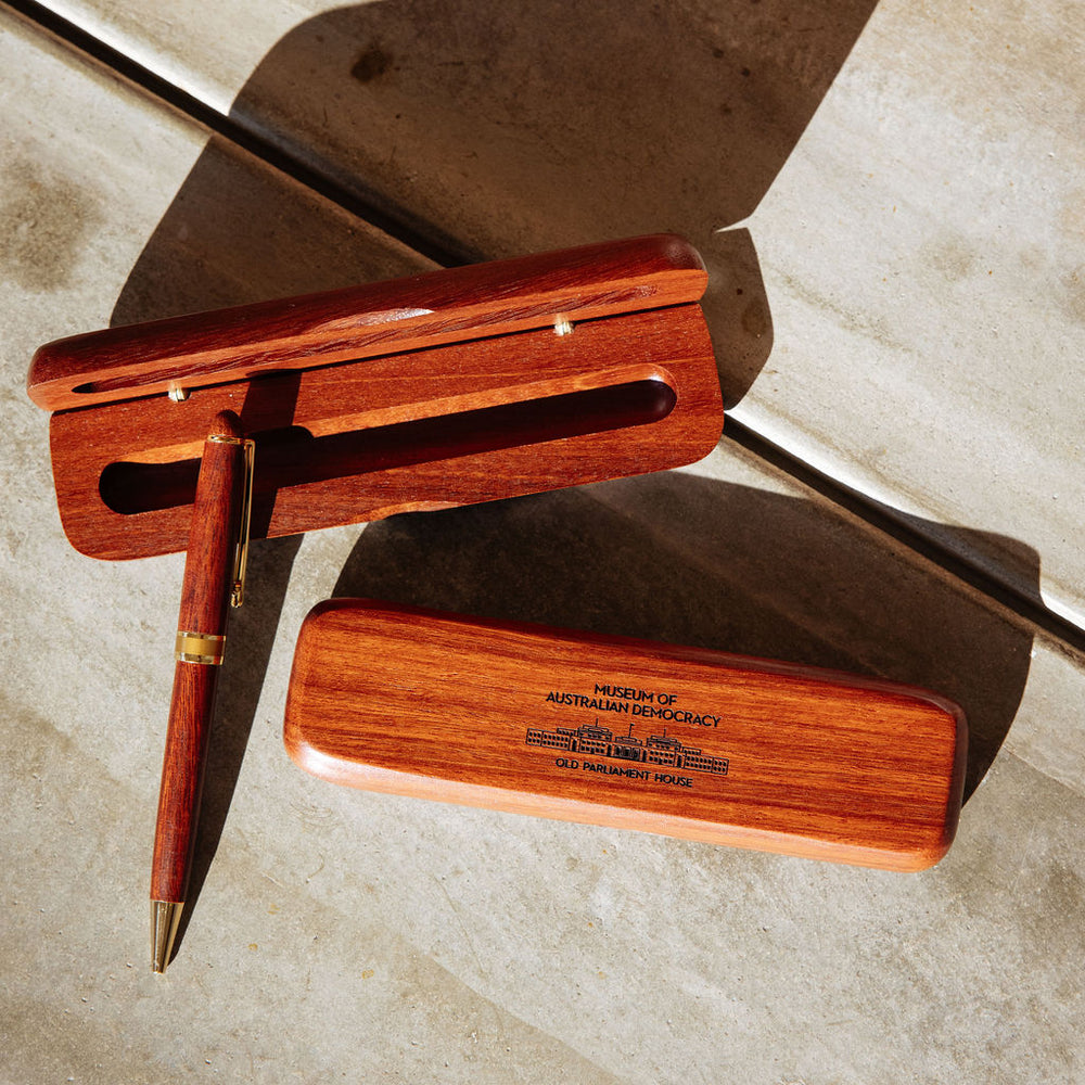 Two wooden boxes and a wooden pen arranged on concrete. 